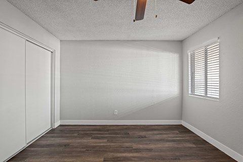 A room with a wooden floor and a ceiling fan.