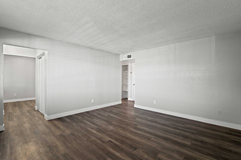 A room with wood flooring and white walls.