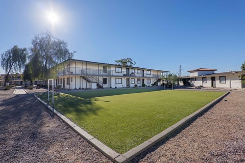 A sunny day at a residential area with a building and a green lawn.
