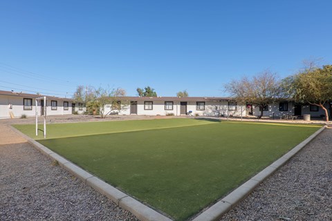 A grassy area in front of a building with a clear blue sky above.