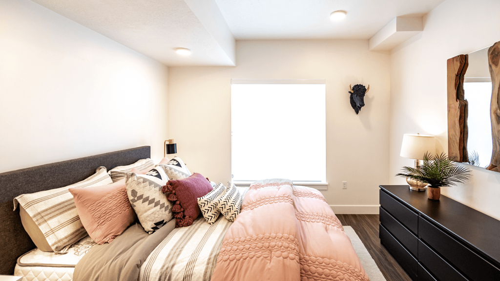 a bedroom with a bed and a dresser and a window