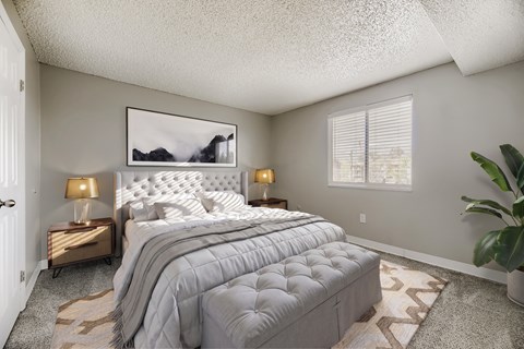 A bedroom with a large bed and a painting on the wall.
