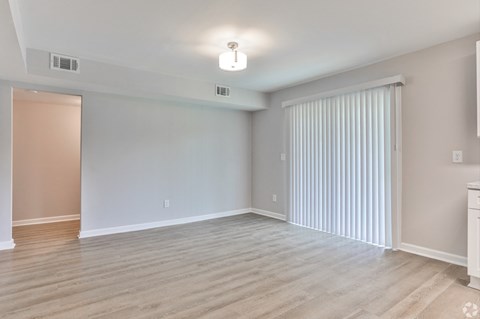 the living room and dining room of an apartment with blinds on the window