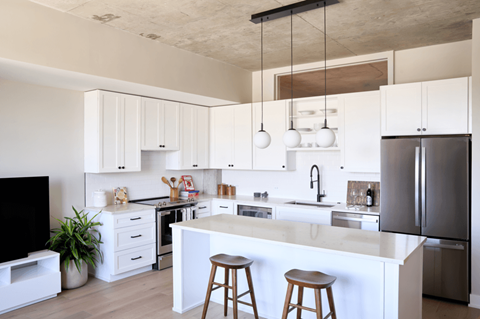 A modern kitchen with white cabinets and a large island.
