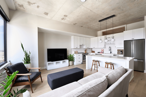 A modern living room with a grey sofa and a wooden chair.