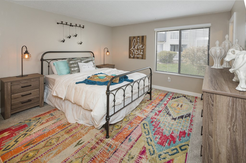 a bedroom with a bed and a dresser and a window