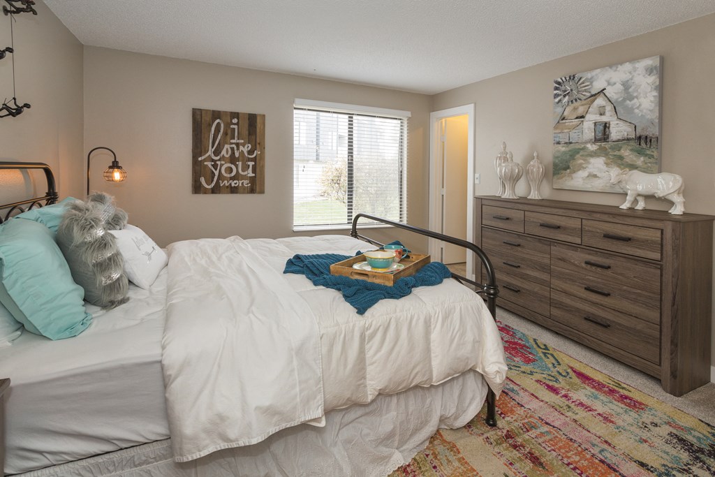 a bedroom with a bed and a dresser and a window