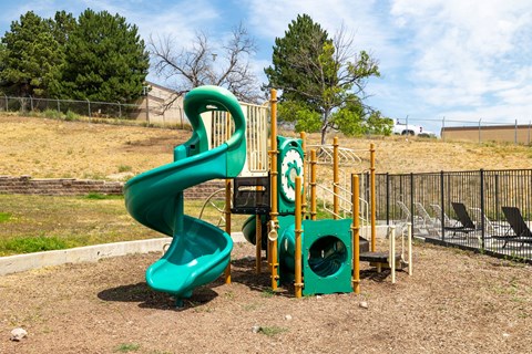 A green slide in a playground with a sign that says 5.