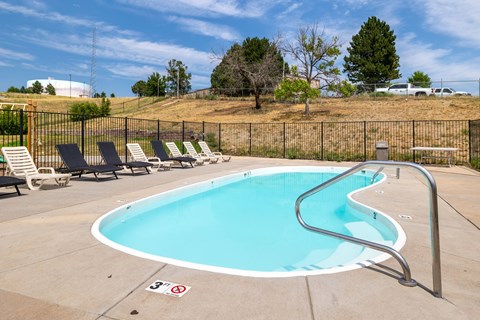 A small pool with a metal fence around it.