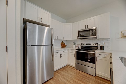 a kitchen with stainless steel appliances and white cabinets