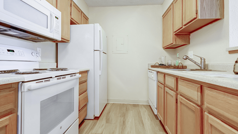 a kitchen with white appliances and wooden cabinets