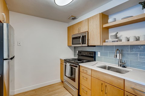 a kitchen with wood cabinets and stainless steel appliances and a sink