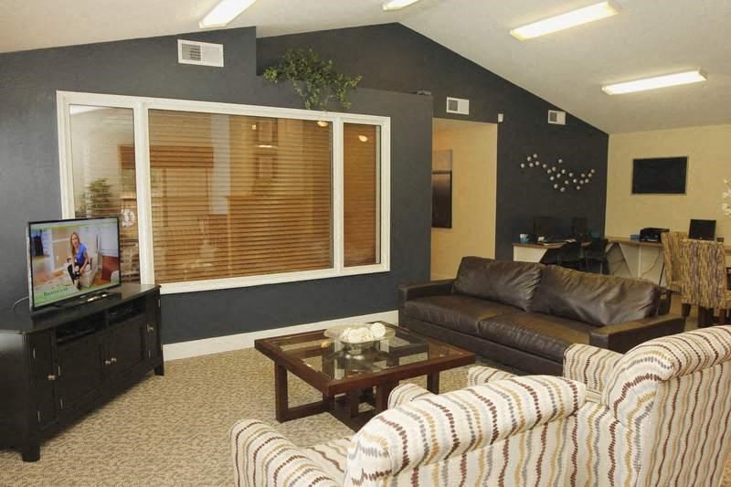 A living room with a couch, a coffee table, and a television.