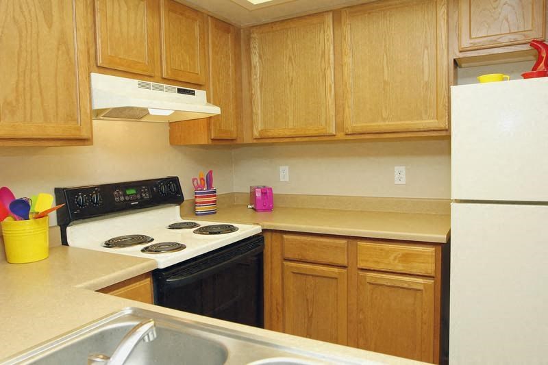 A kitchen with wooden cabinets and a black stove top.