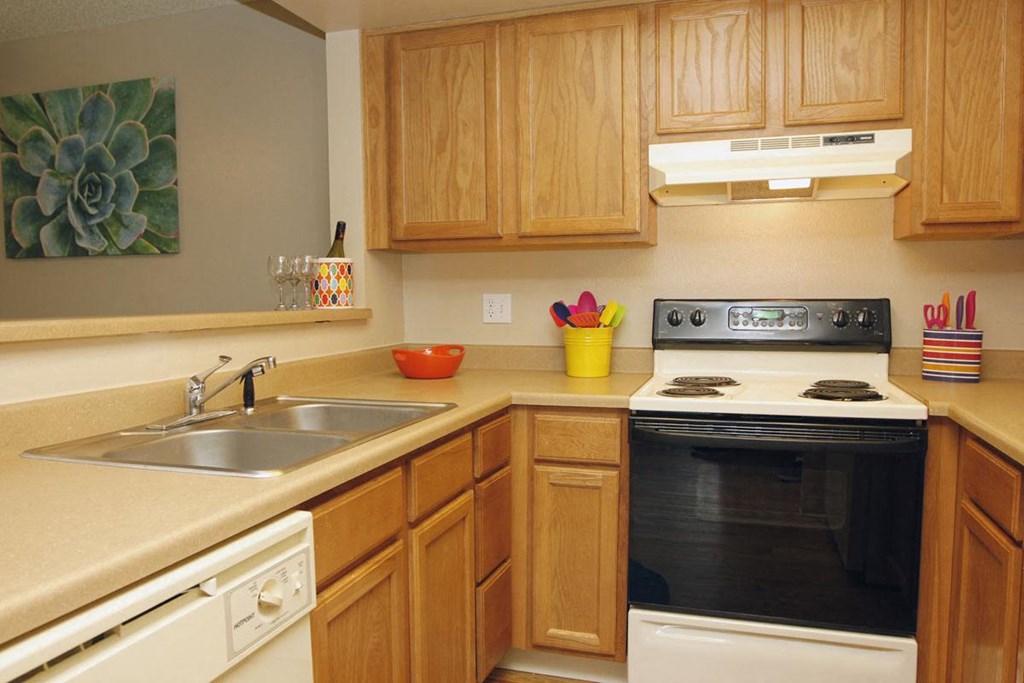 A kitchen with wooden cabinets and a black oven.