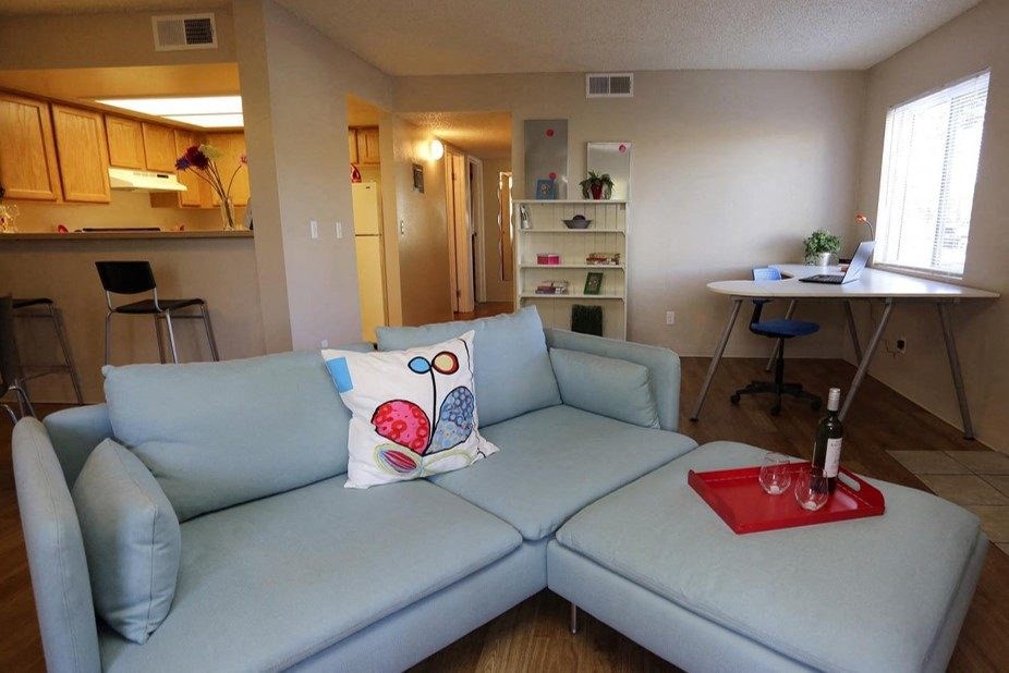 A blue couch with a red tray on it in a living room.