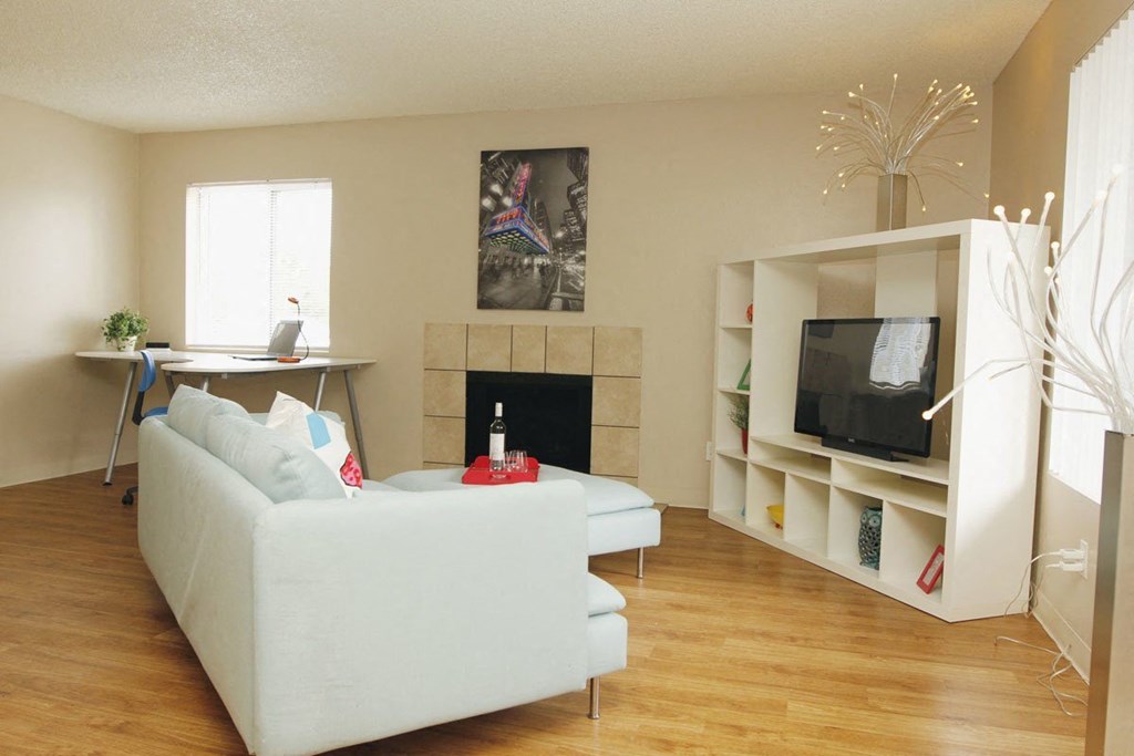 A living room with a white couch and a fireplace.