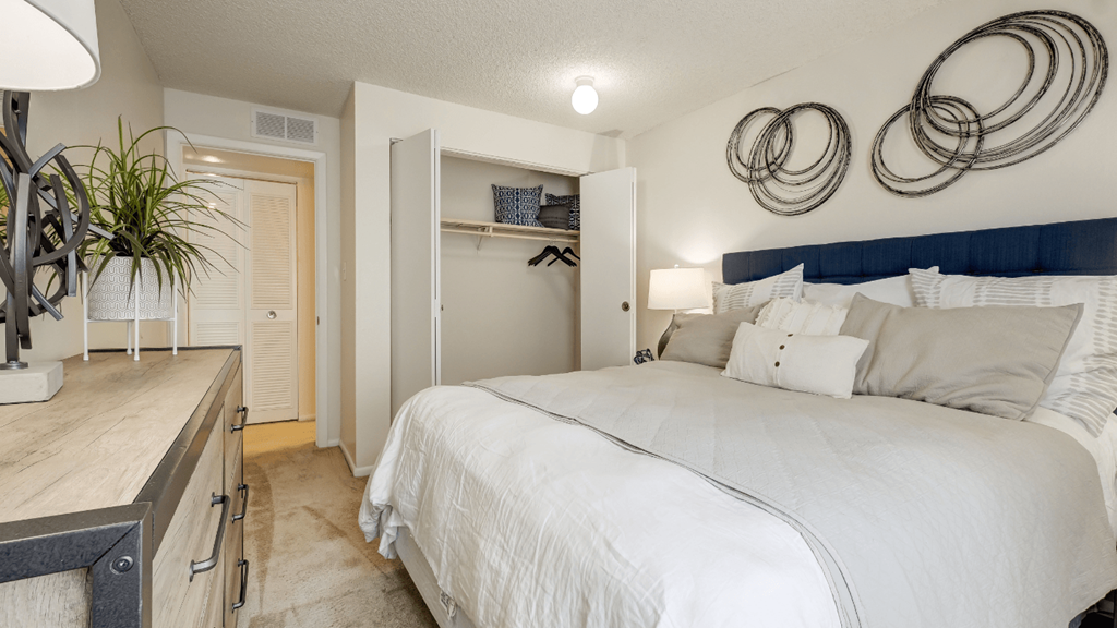 a bedroom with a white bed and a closet