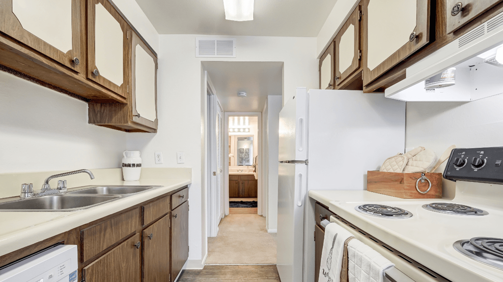 a kitchen with white appliances and wooden cabinets and a white refrigerator