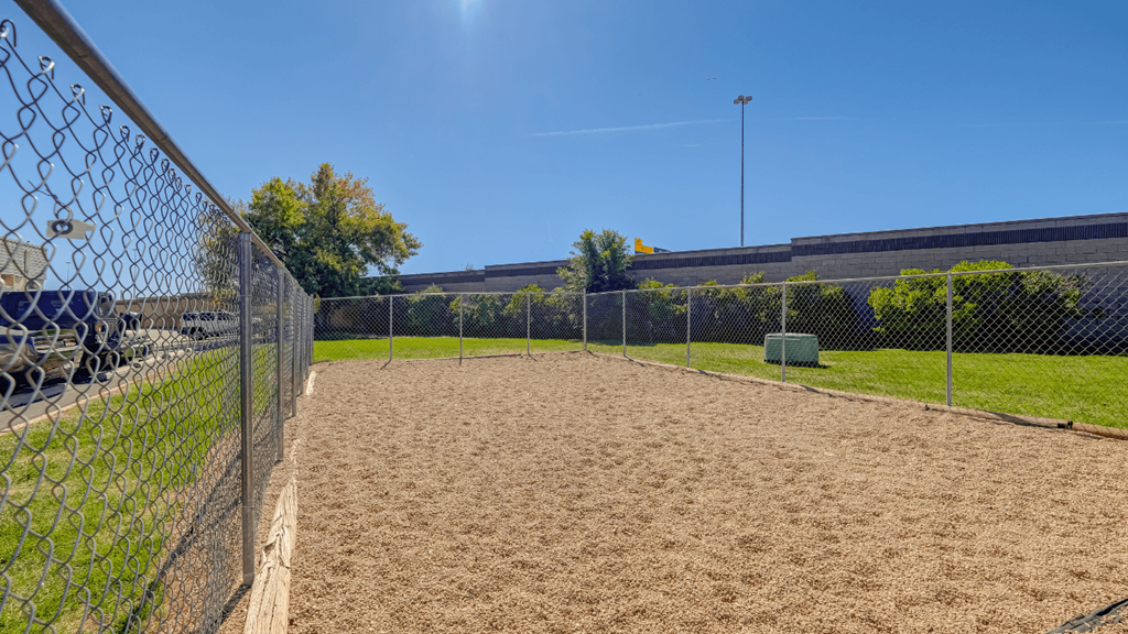 a fenced in dog park with a chain link fence