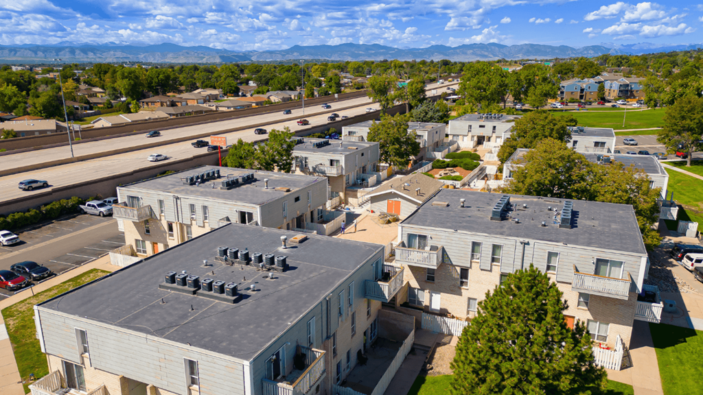 an aerial view of buildings with roofs and a highway in the background