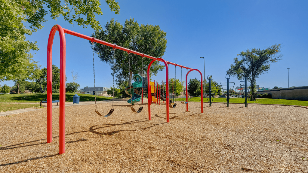 a playground with monkey bars and swings in a park
