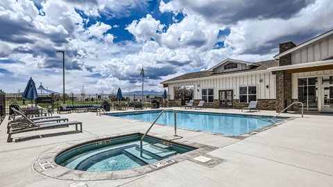 A large outdoor swimming pool with a hot tub in the middle.