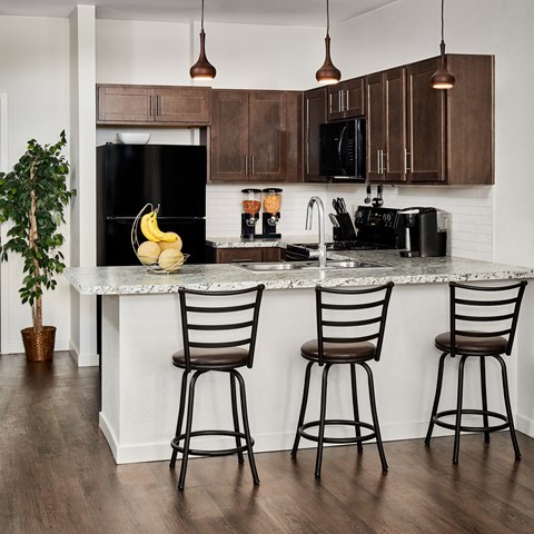 a kitchen with a counter and three bar stools