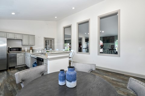 A modern kitchen with a wooden table and chairs.