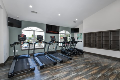 A gym with treadmills and a flat screen TV.