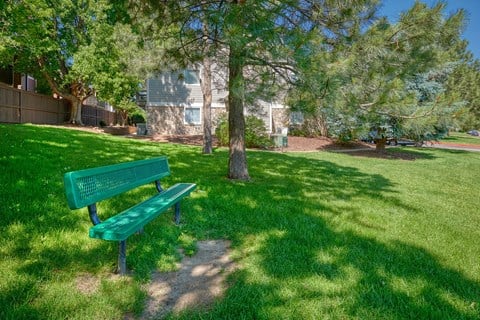 a green park bench sitting in the grass