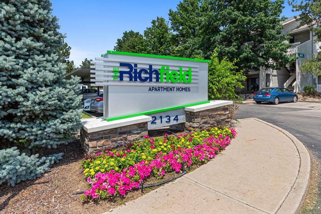 the sign homes in front of a flower garden