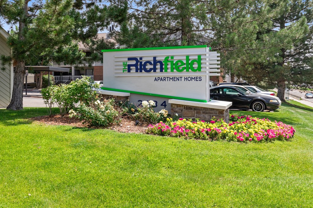 the sign in front of a yard of flowers