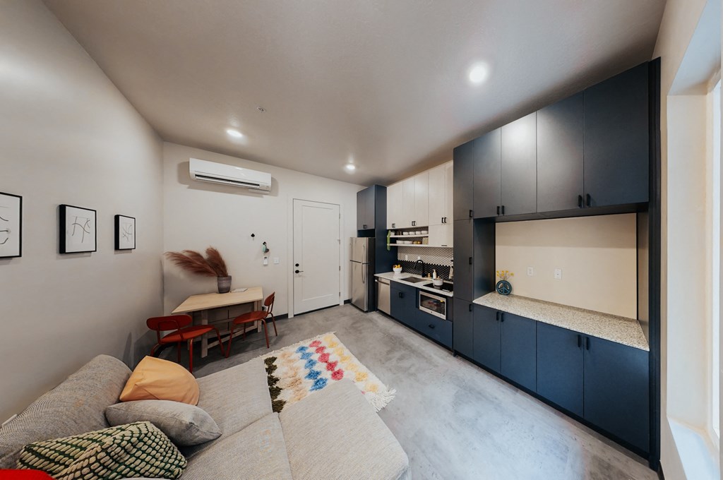 a living room with a couch and a kitchen