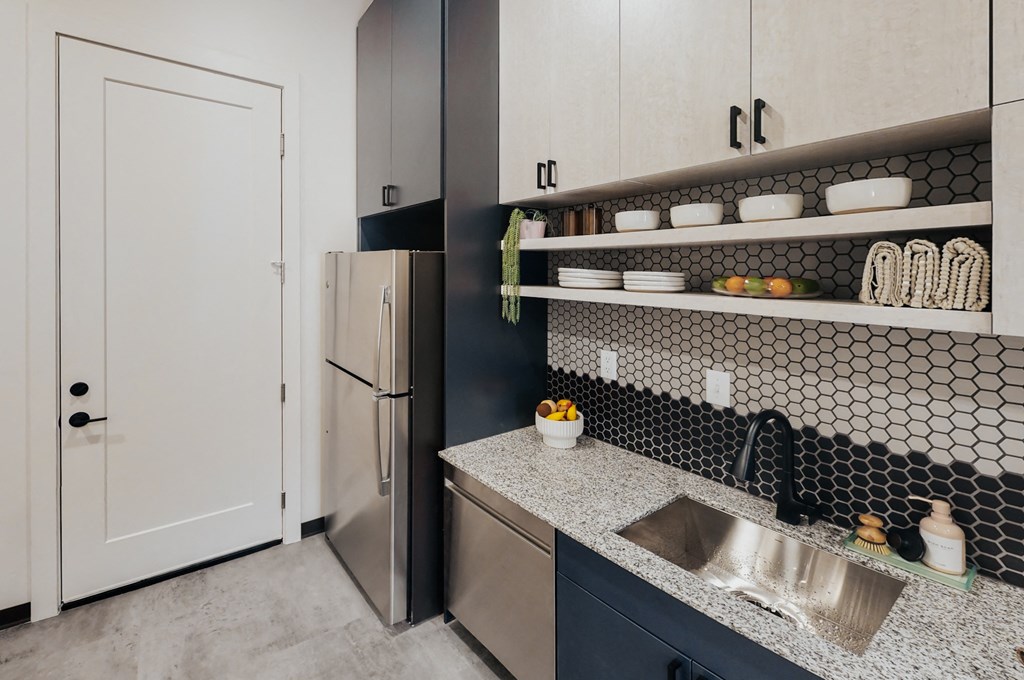 a kitchen with white cabinets and a sink and a refrigerator
