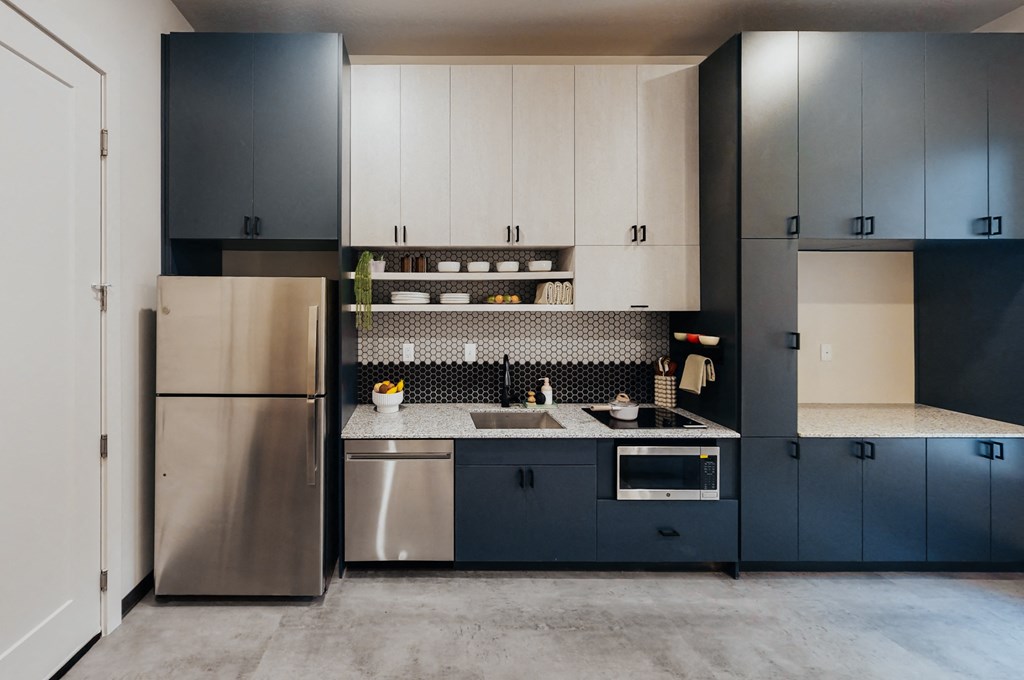 a kitchen with blue and white cabinets and stainless steel appliances