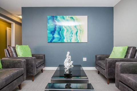 A living room with a large painting on the wall and a sculpture on the coffee table.