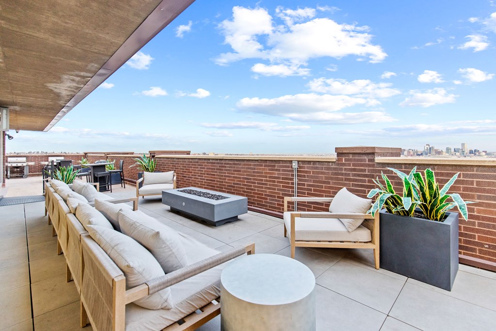 a rooftop terrace with a couch and a fire pit