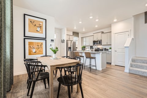 A modern kitchen with a dining table and chairs.