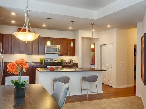 A kitchen with a table and chairs in front of it.