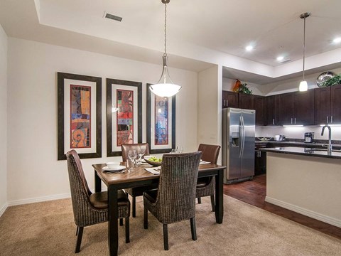 A dining room with a table and chairs.