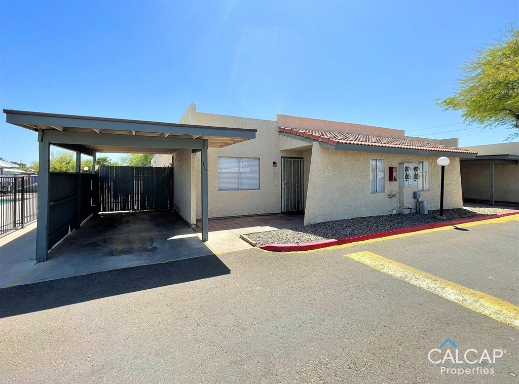 A building with a covered parking area in front.