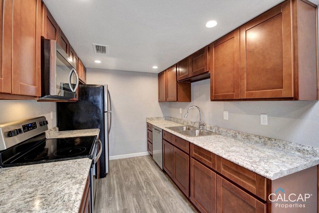 A kitchen with wooden cabinets and granite countertops.