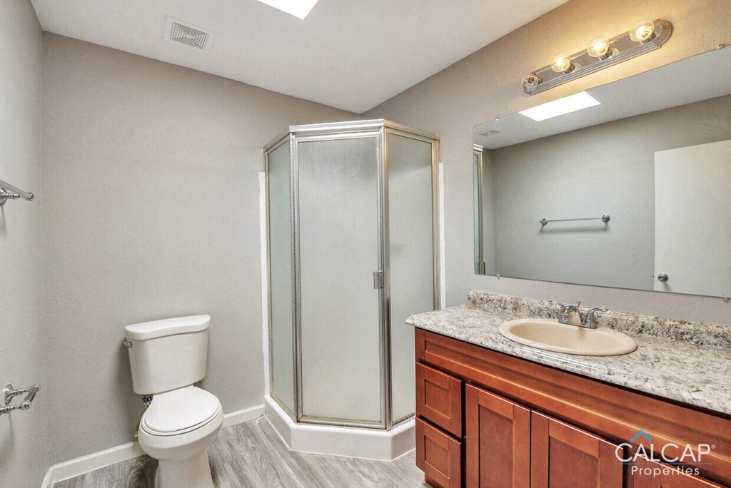 A bathroom with a toilet, sink, and shower.