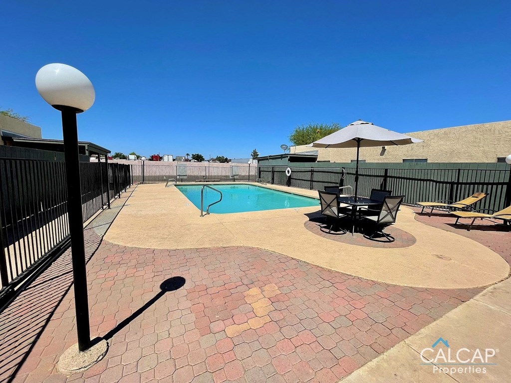 A pool area with a black fence and a pool table.