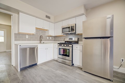A modern kitchen with stainless steel appliances and white cabinets.