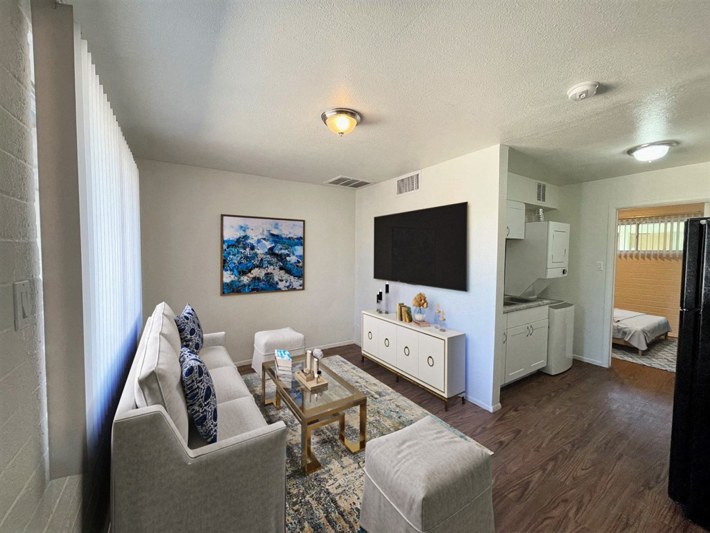 A living room with a grey couch, a coffee table, and a painting on the wall.