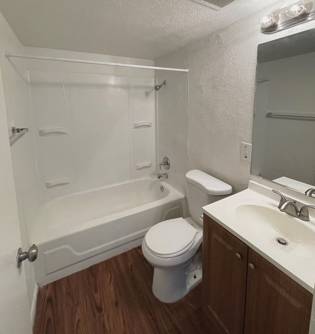 A white toilet sits next to a white sink in a small bathroom.