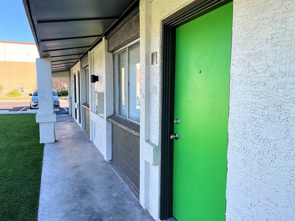 A long hallway with a green door at the end.