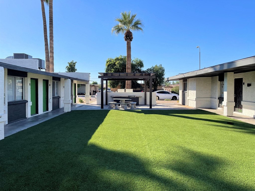 A sunny day at a park with a picnic table and palm trees.